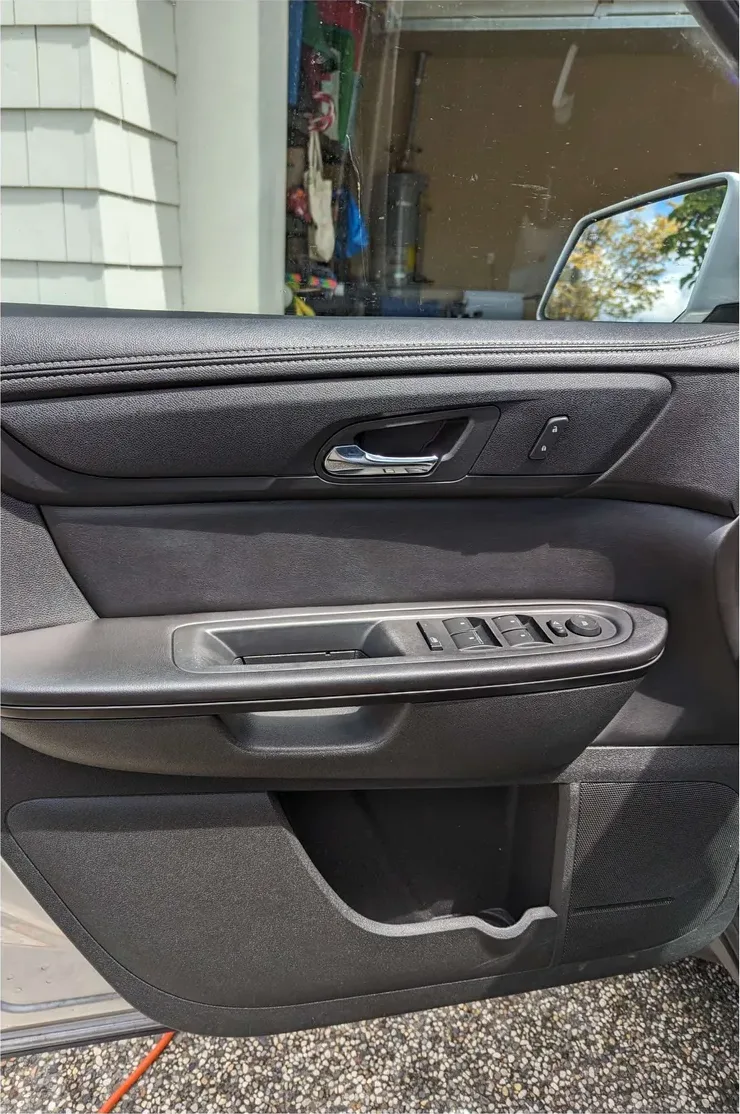 The same door panel after: armrest and handle area clean, door pocket emptied and wiped