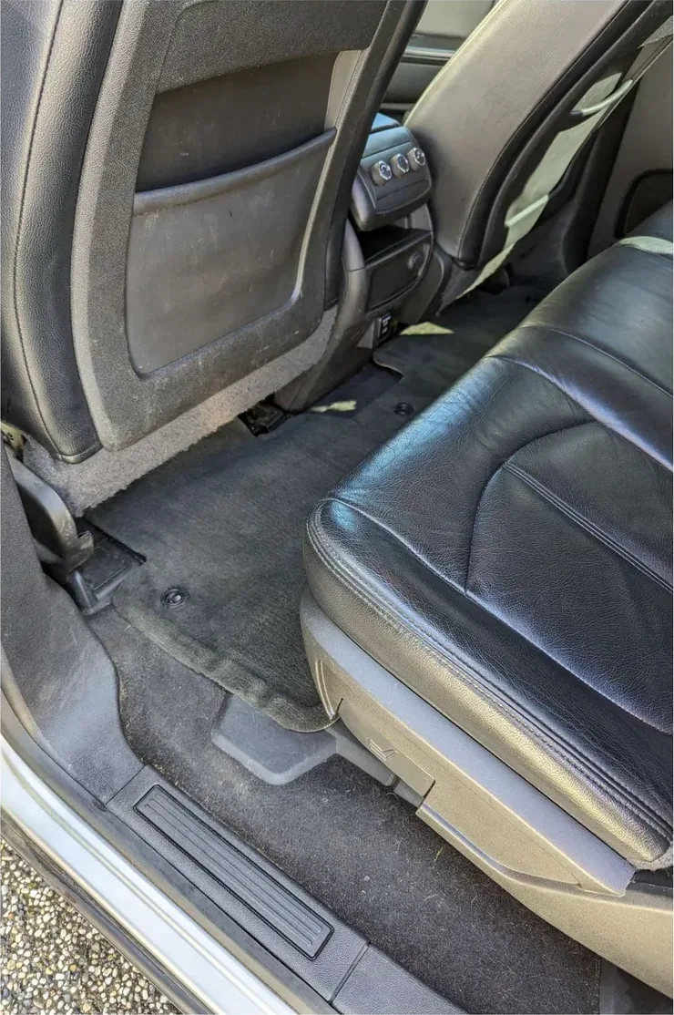 The same rear footwell after: carpet extracted to an even dark finish, seat back and trim wiped