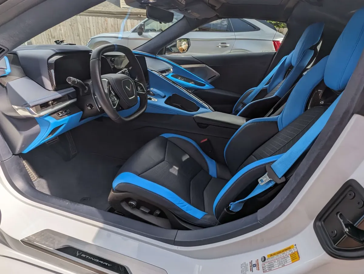 The driver seat and dash of the Corvette, blue and black leather cleaned and conditioned