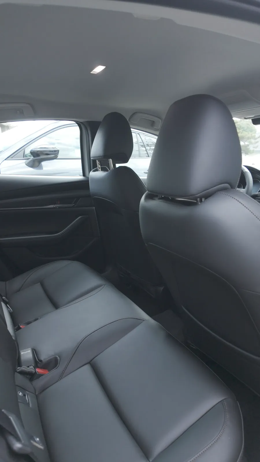 The rear cabin of a Mazda3 after detailing: leather seats, door card and headliner cleaned and left matte